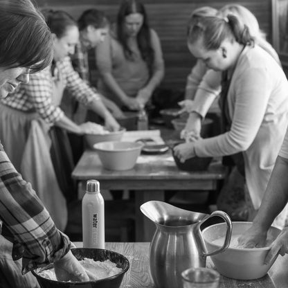 Group of people working together in a kitchen, preparing food.